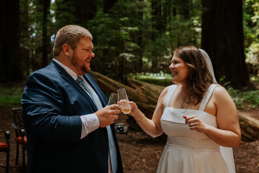 couple celebrates with champagne after eloping in the redwoods